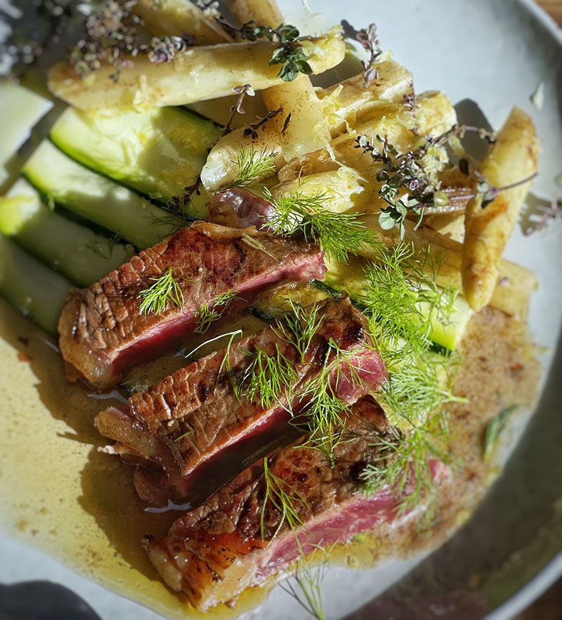 Grillet irsk sirloin oksekød på smørbrændte hvide asparges og citronsquash